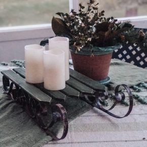 candles on a christmas sled on the front porch