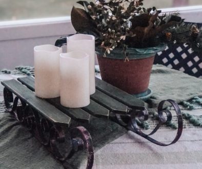 candles on a christmas sled on the front porch